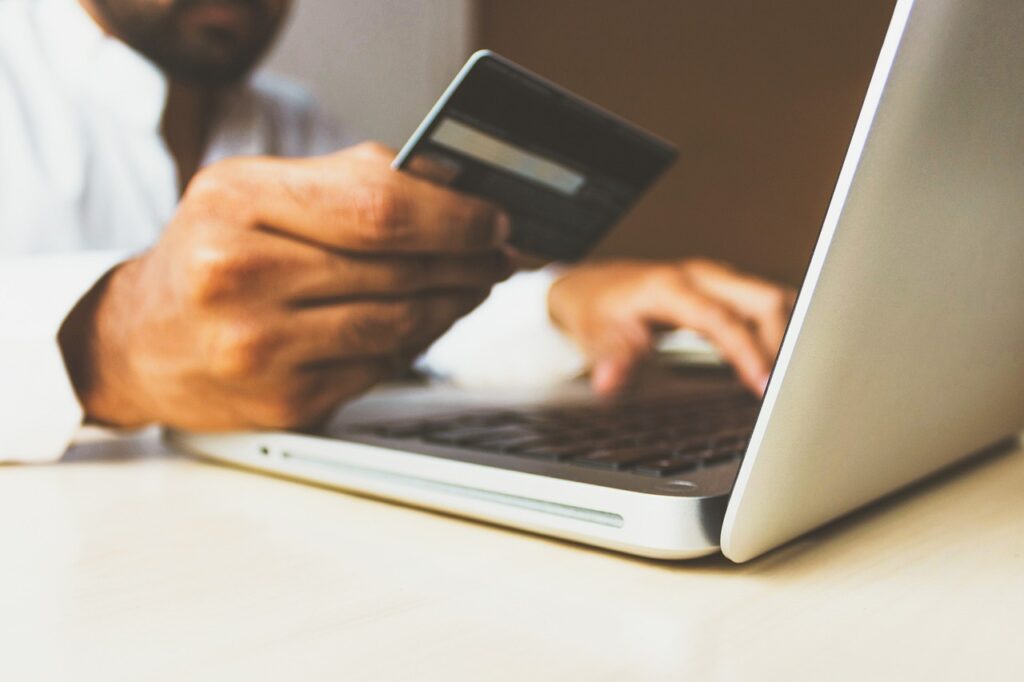 PCI Compliance with IP Fabric; a man makes a online shopping transaction using a debit card. 